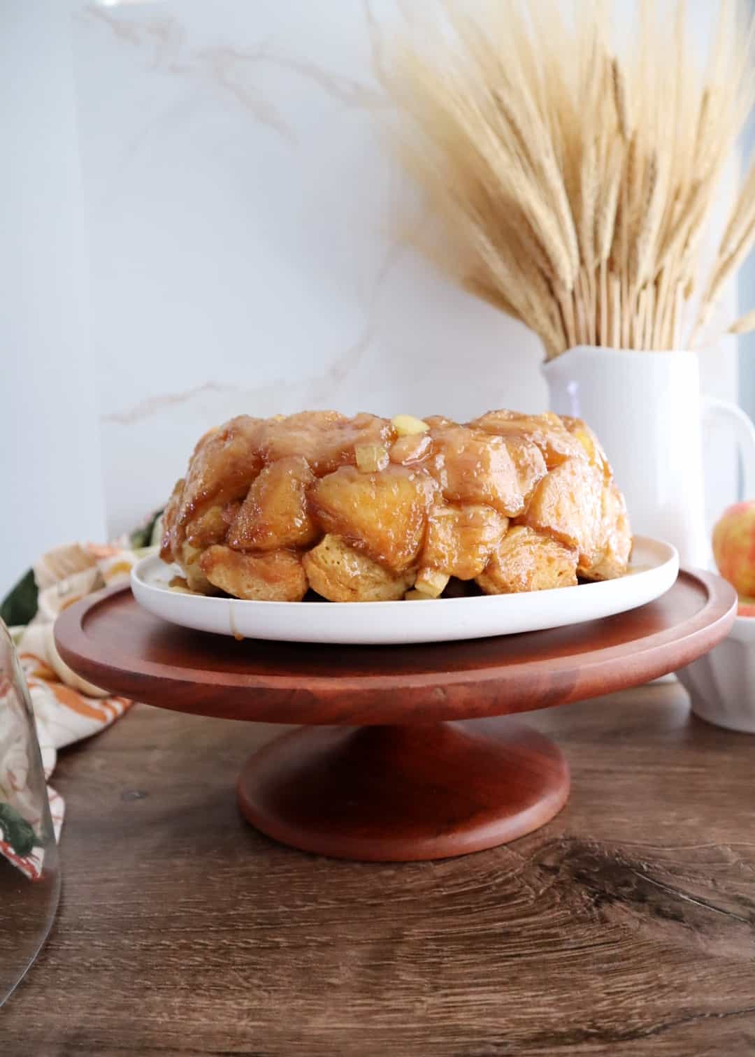 apple monkey bread on wooden cake stand