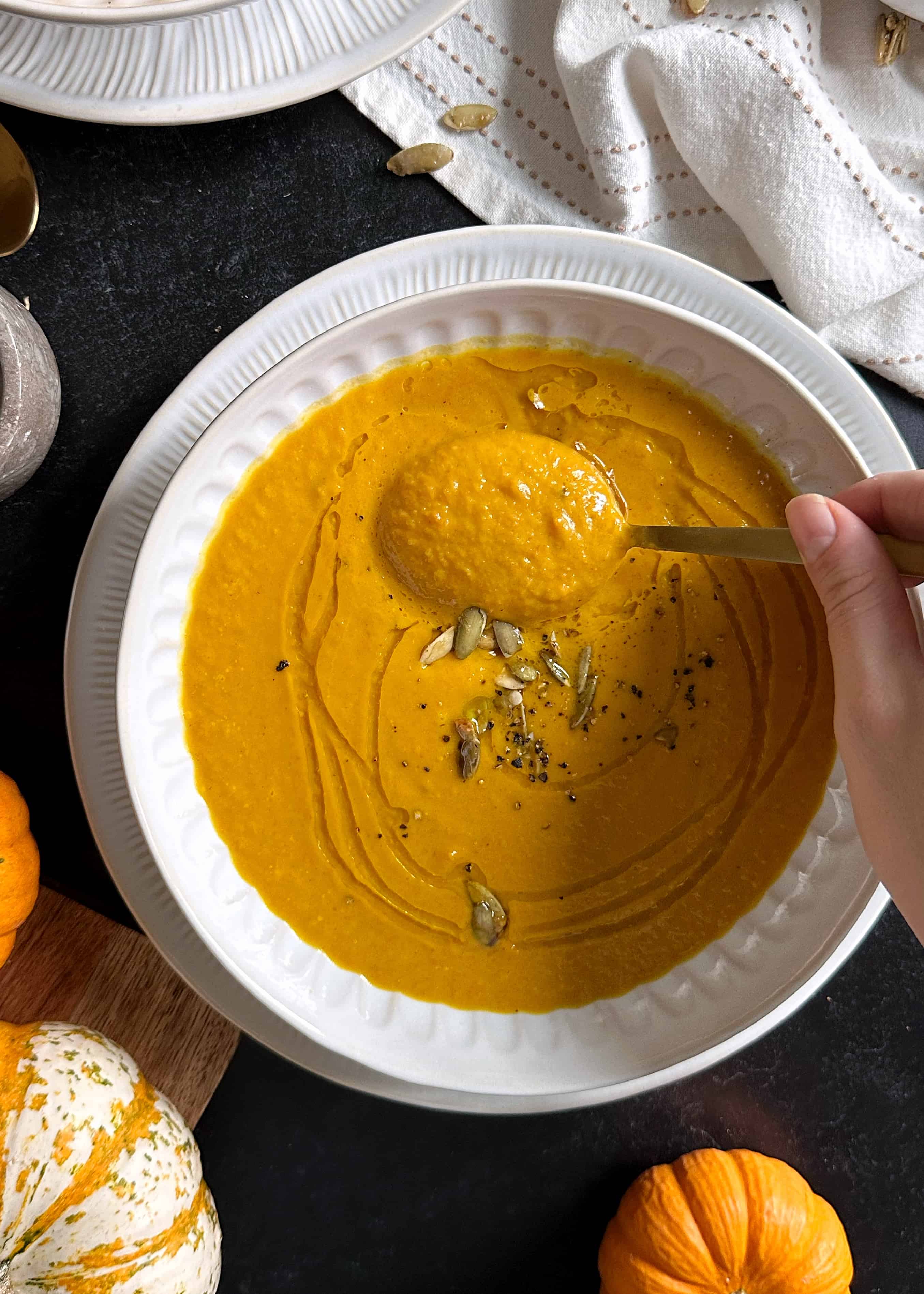 curry pumpkin carrot soup with gold spoon