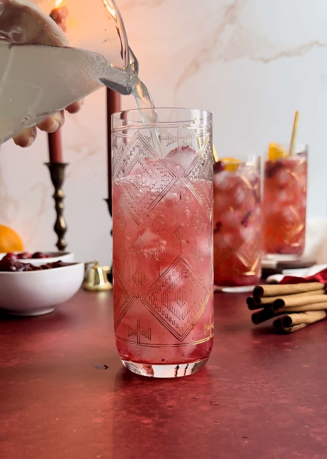 pouring ginger beer into a cranberry sauce mule