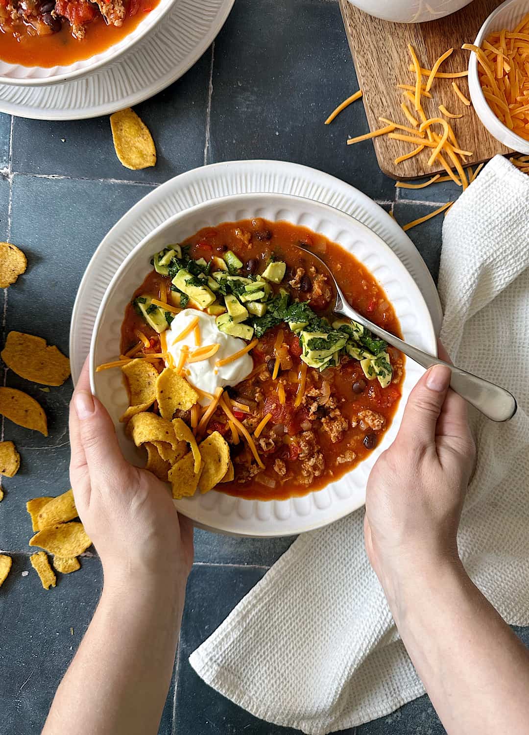 bowl of turkey and bean chili with avocado salsa