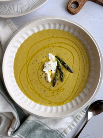 bowl of chilled asparagus soup with yogurt and asparagus top garnish
