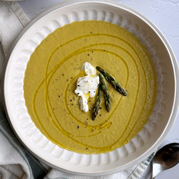 bowl of chilled asparagus soup with yogurt and asparagus top garnish