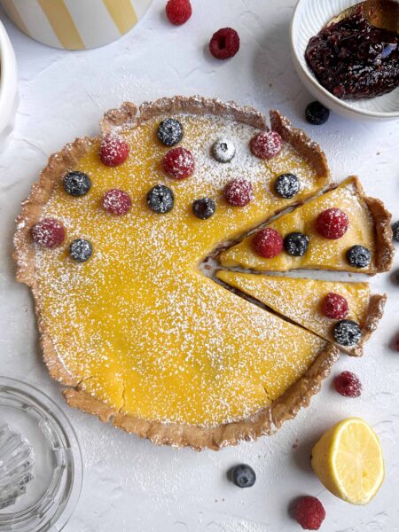 lemon raspberry tart with two slices cut into it