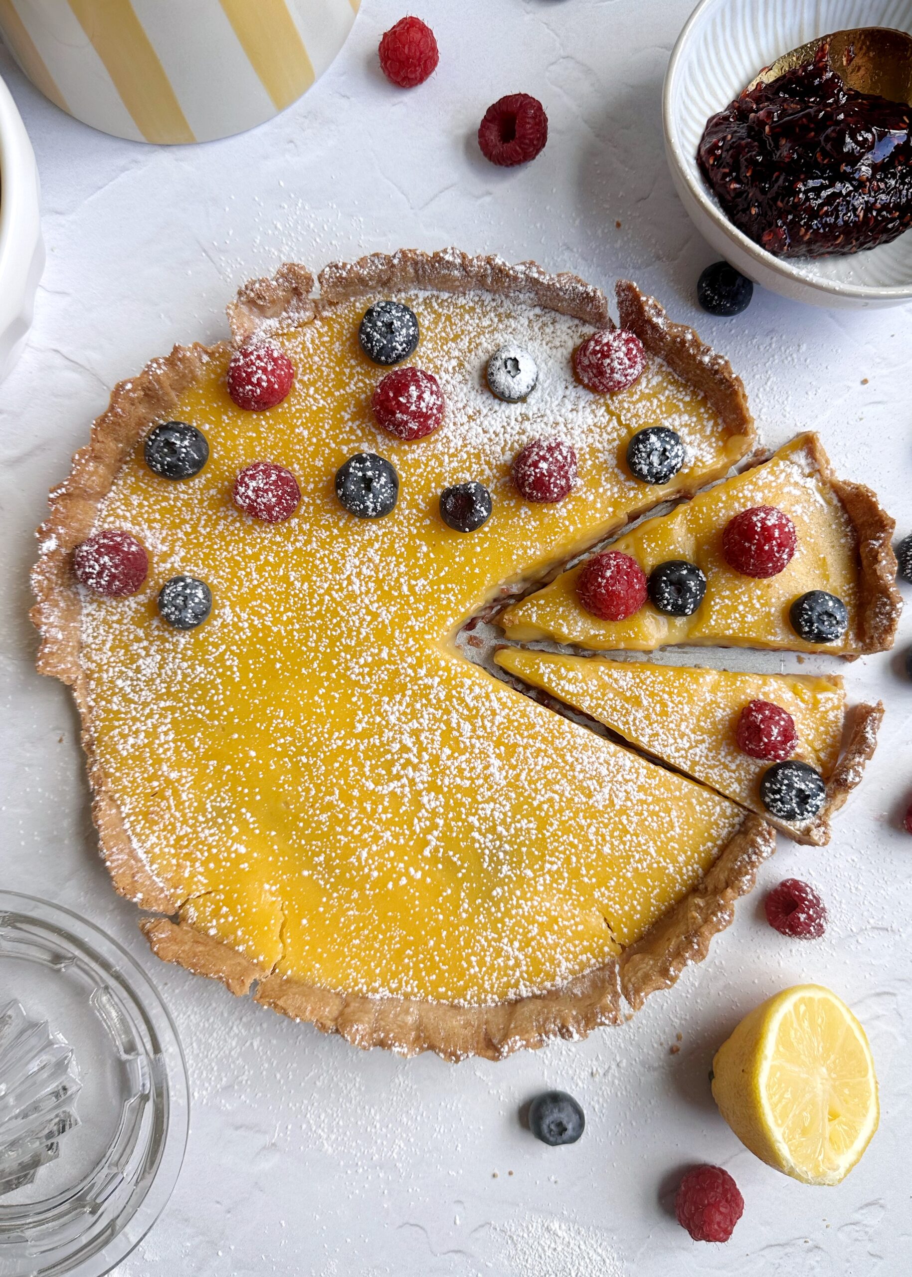 lemon raspberry tart with two slices cut into it