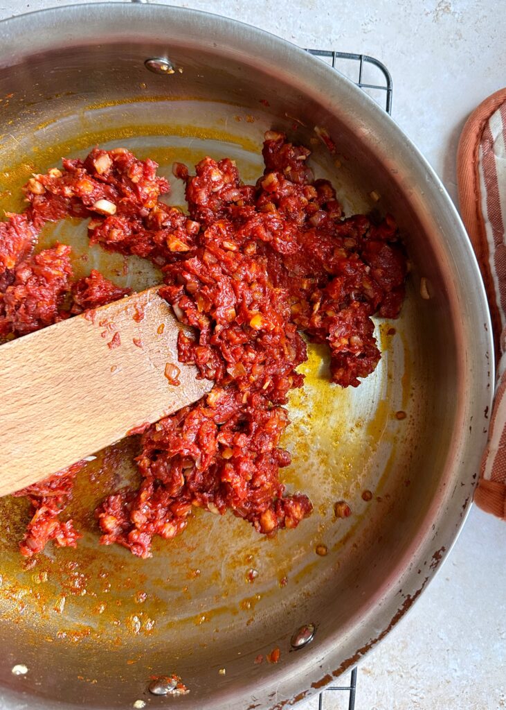 sauteed tomato shallot garlic and calabrian chili in saute pan