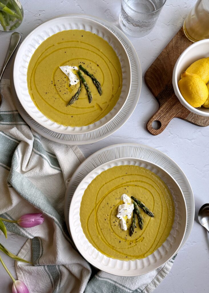 two bowls of chilled asparagus soup with yogurt garnish