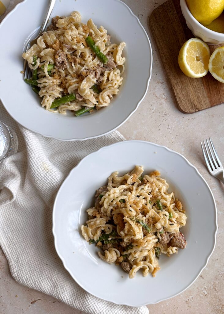 two bowls of lemon asparagus goat cheese pasta with italian sausage