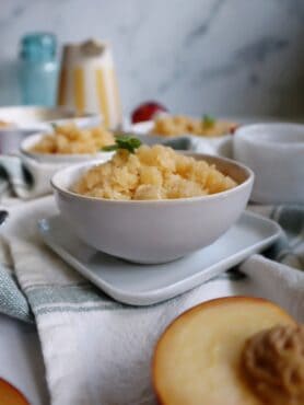 white bowl with peach basil granita and basil garnish