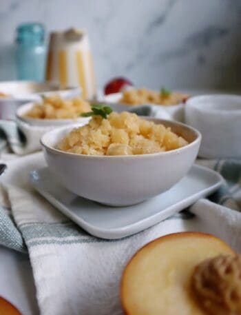 white bowl with peach basil granita and basil garnish