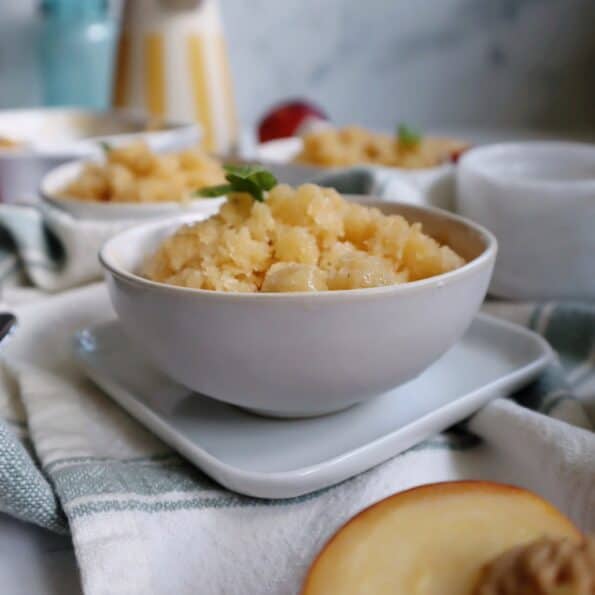 white bowl with peach basil granita and basil garnish