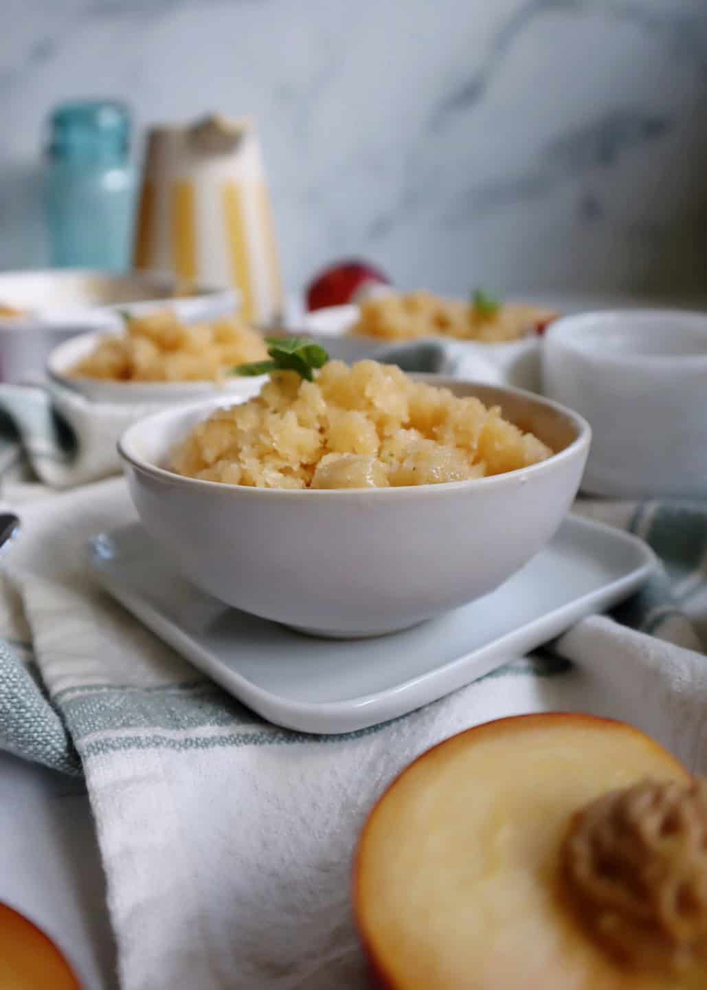 white bowl with peach basil granita and basil garnish