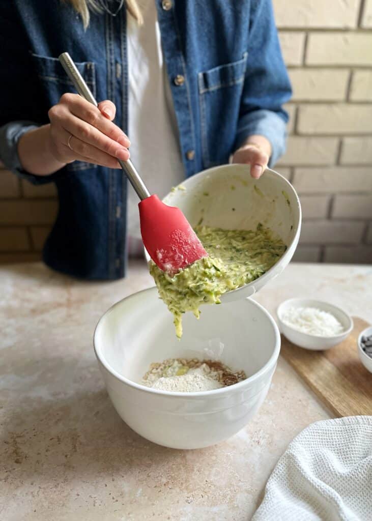 adding wet ingredients to dry ingredients for zucchini bread