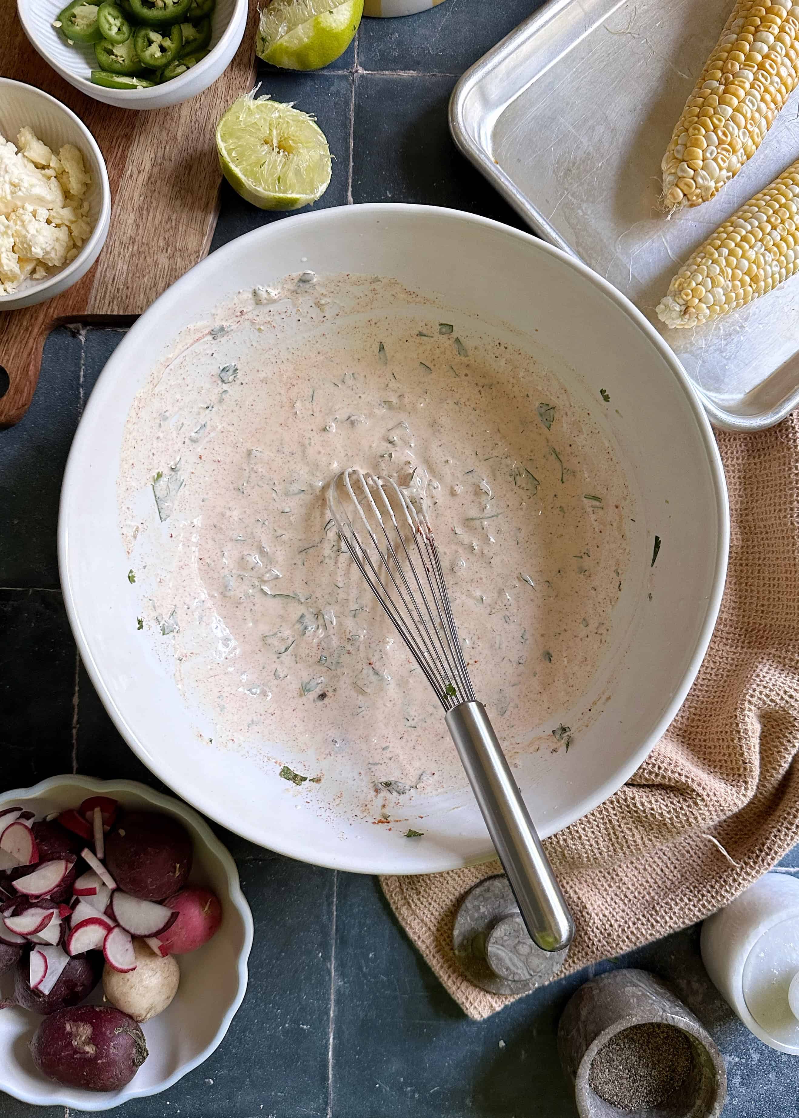 bowl of elote potato salad dressing with whisk