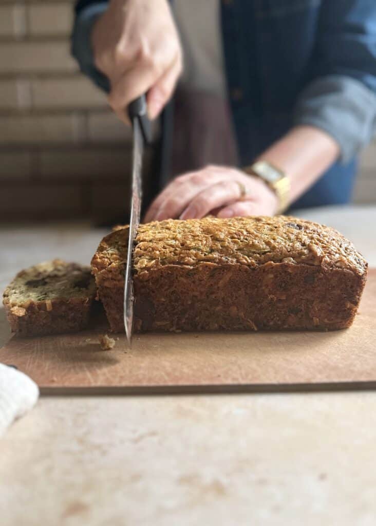 cutting slices of zucchini bread from the loaf