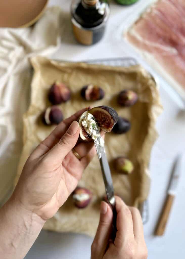 filling sliced fig with goat cheese and basil