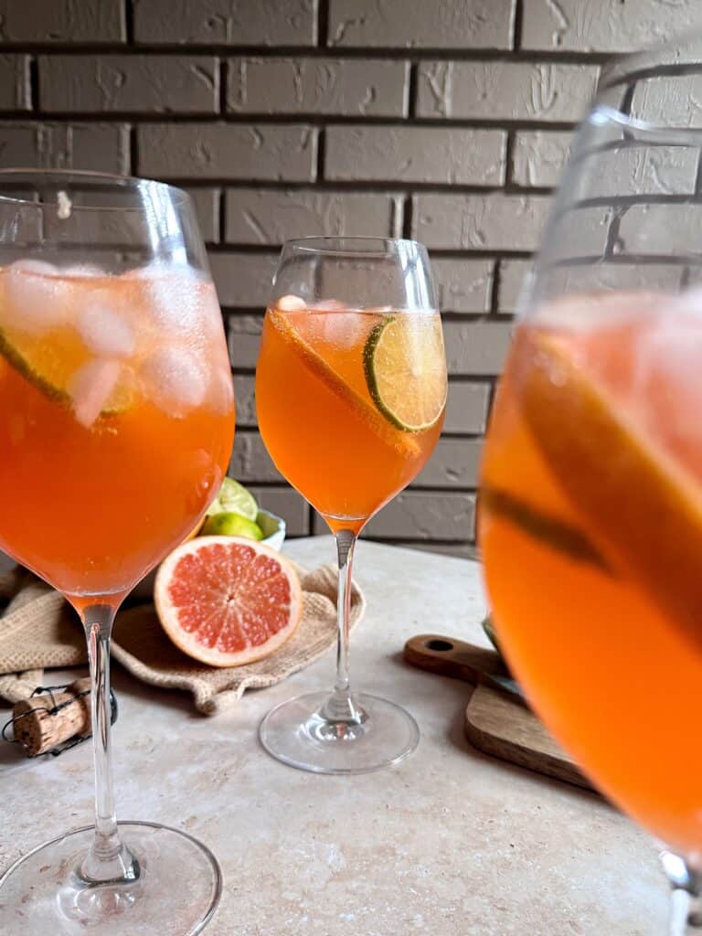 three glasses of aperol paloma spritzes