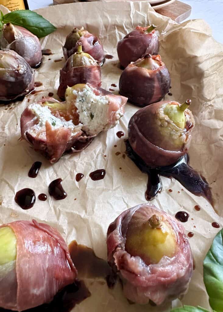 tray of baked figs wrapped in prosciutto and balsamic