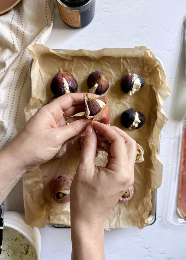 wrapping goat cheese stuffed fig with prosciutto