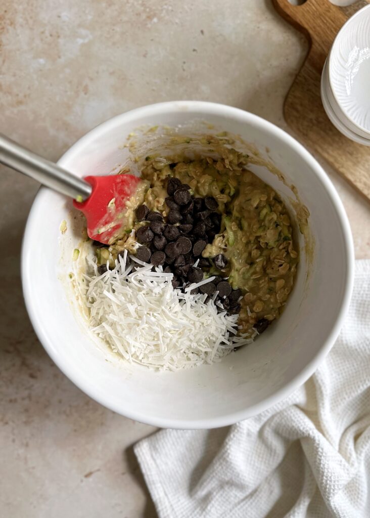 zucchini bread with oatmeal coconut and chocolate chip ingredients in a white bowl