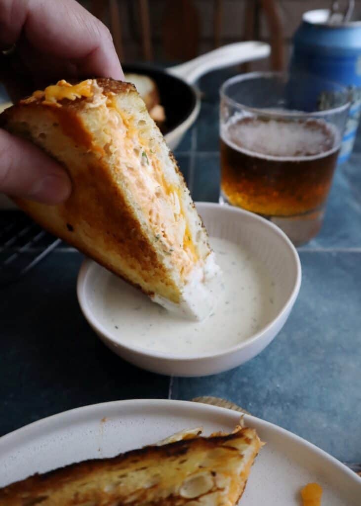 dipping spicy buffalo chicken grilled cheese in ranch dressing