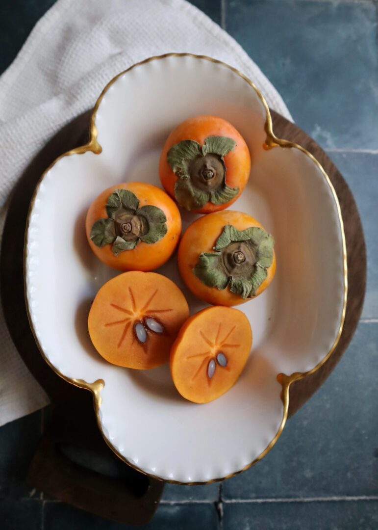 fresh persimmons in a white bowl