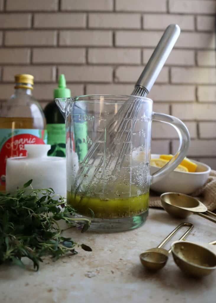 glass measuring cup with thyme vinaigrette