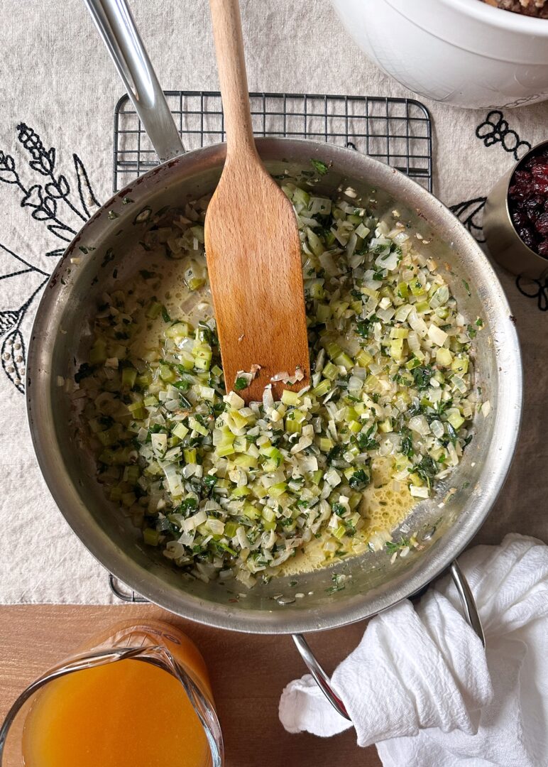 onions celery and herbs sauteed in butter in stainless steel pan