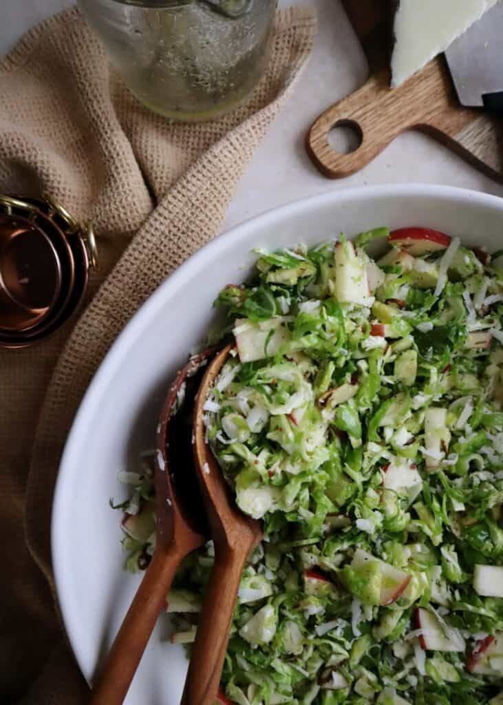 shaved brussels sprouts salad with apple manchego and almond in white bowl