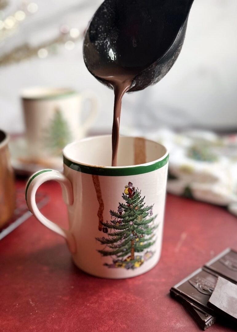 pouring tahini hot chocolate into a mug with a ladle