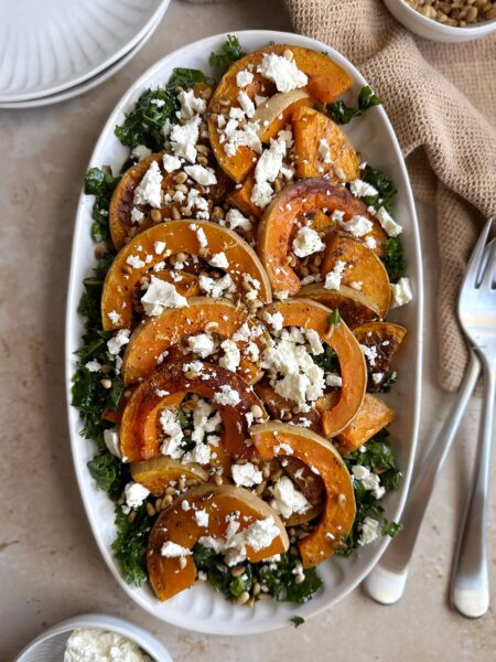 serving tray of butternut squash kale salad feta and pine nuts