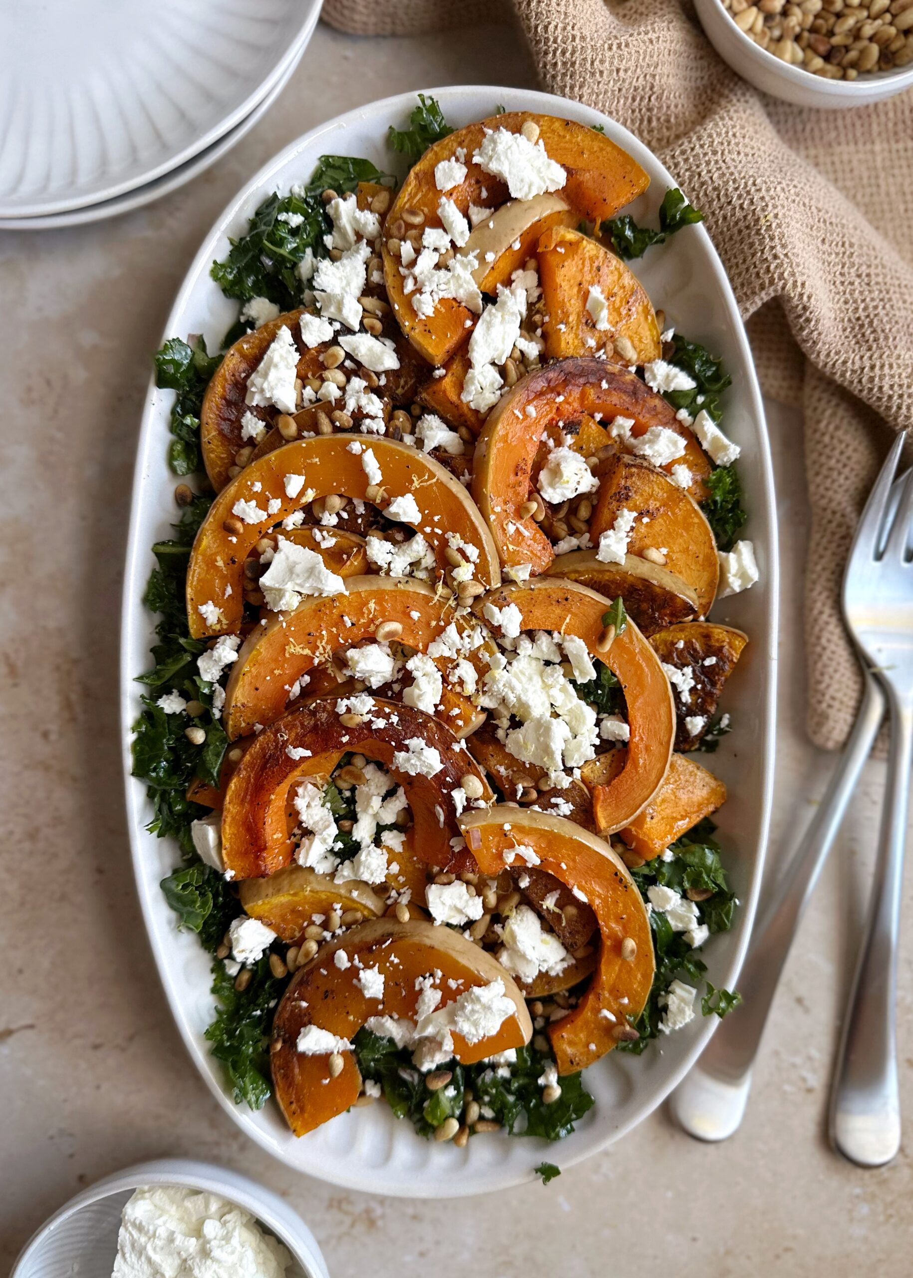 serving tray of butternut squash kale salad feta and pine nuts