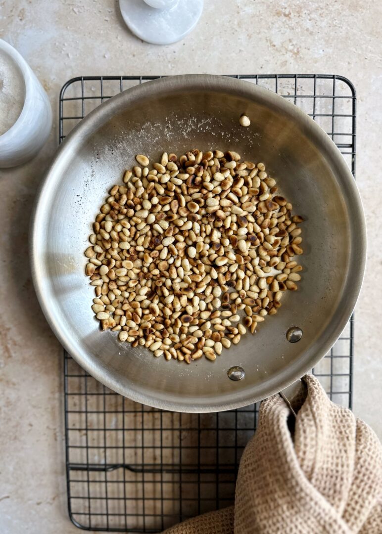 toasted pine nuts in steel frying pan