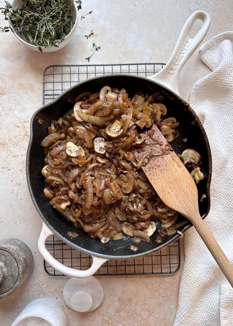 caramelized onions and mushrooms in white cast iron pan