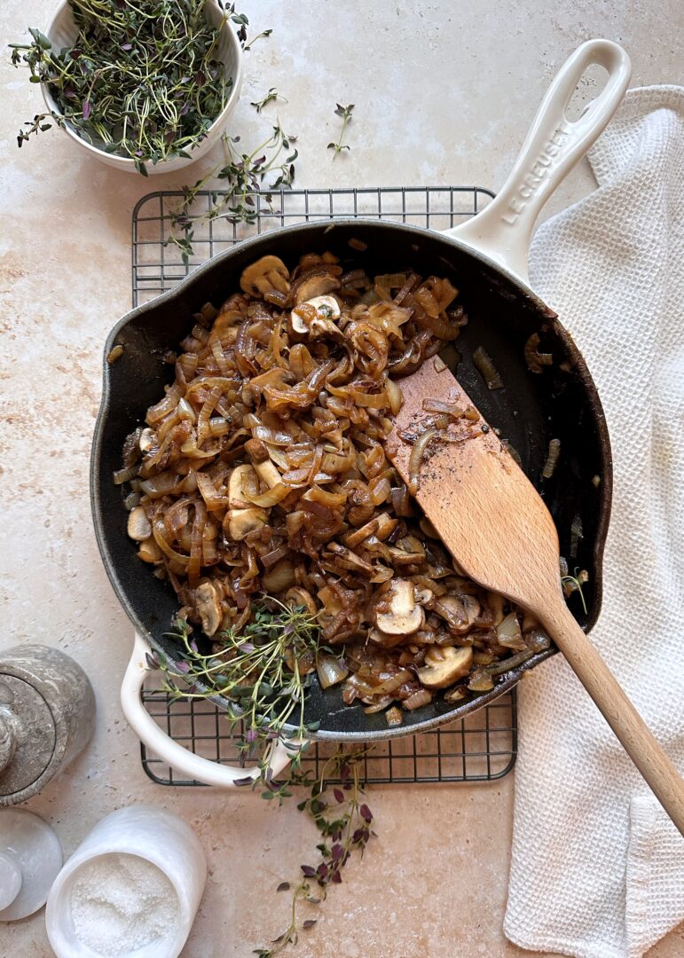 caramelized onions and mushrooms with fresh thyme in cast iron skillet