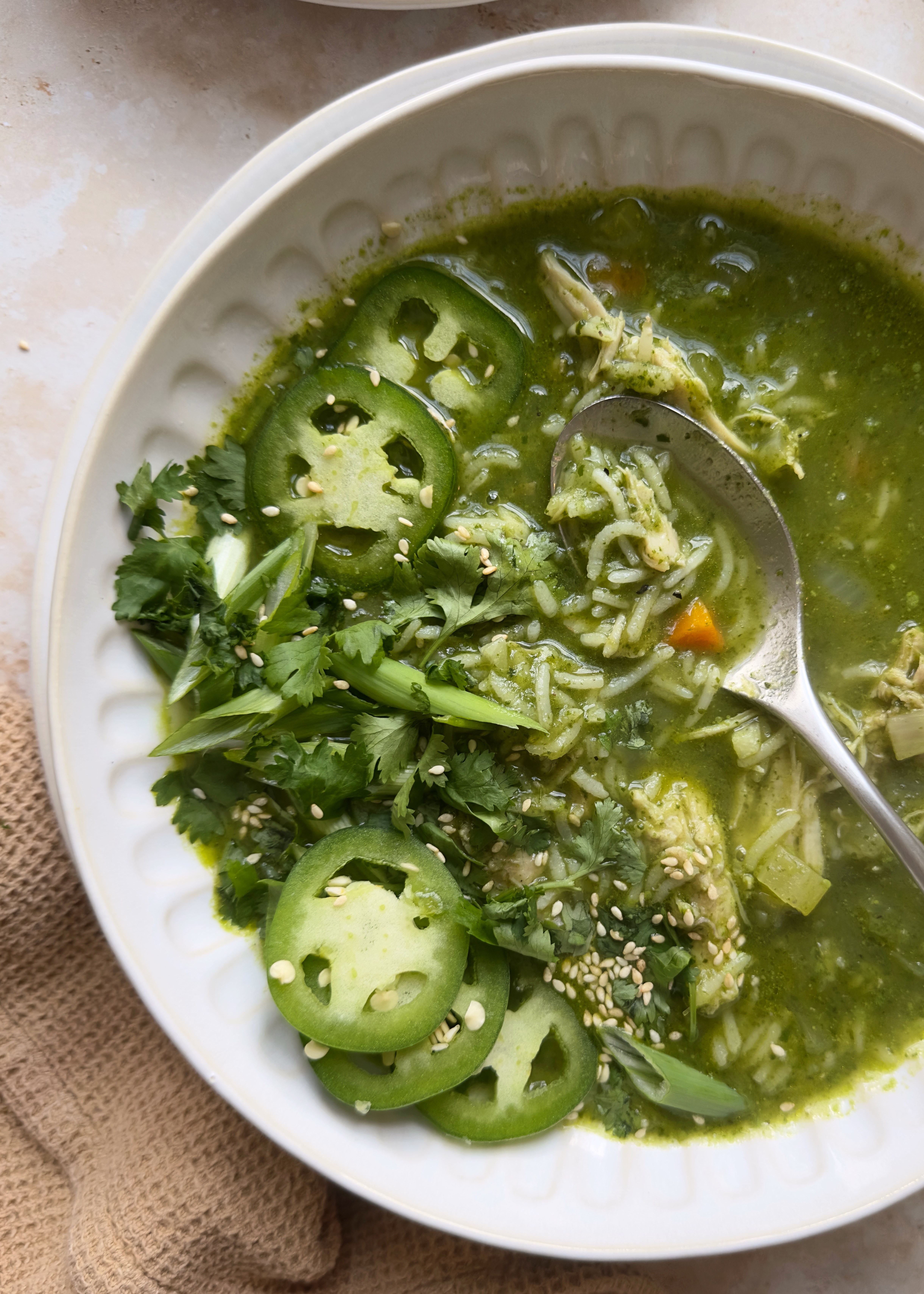 green ginger chicken and rice soup with jalapeno and herb garnish