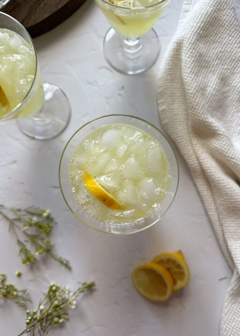 glass of ginger turmeric lemonade with lemon garnish