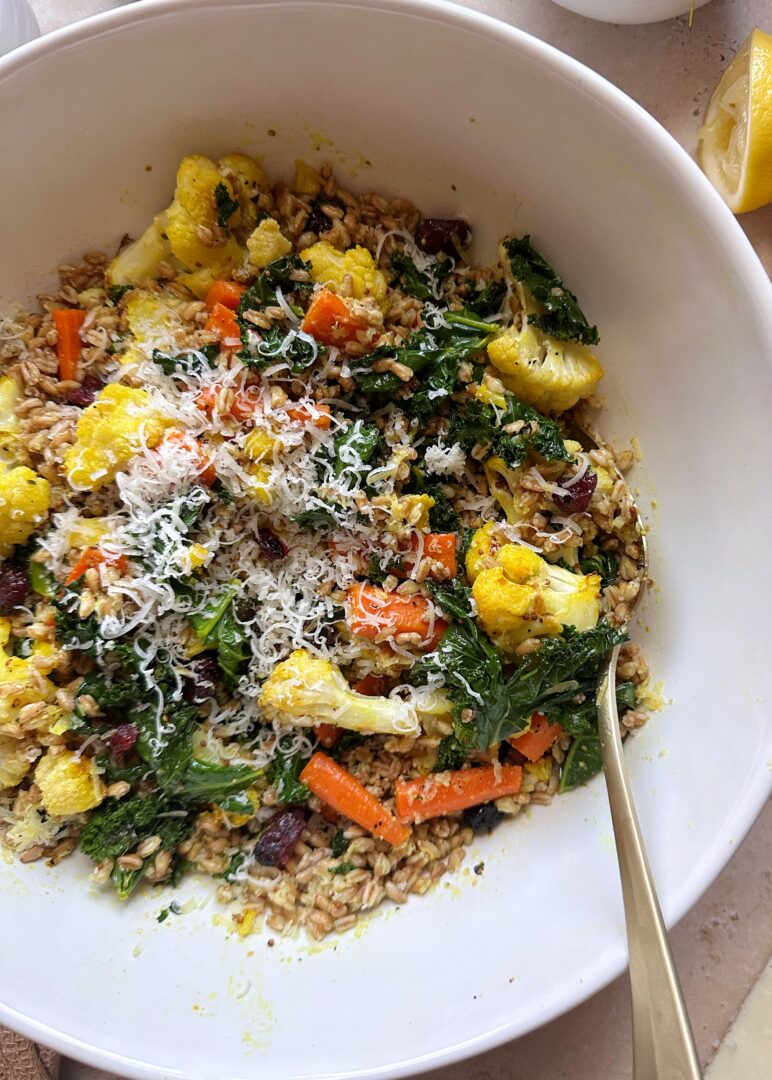 roasted vegetable and grain salad with gold serving spoon