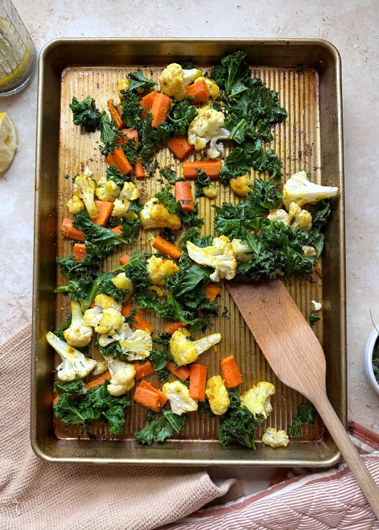 roasted winter vegetables on cooking tray with wooden spatula