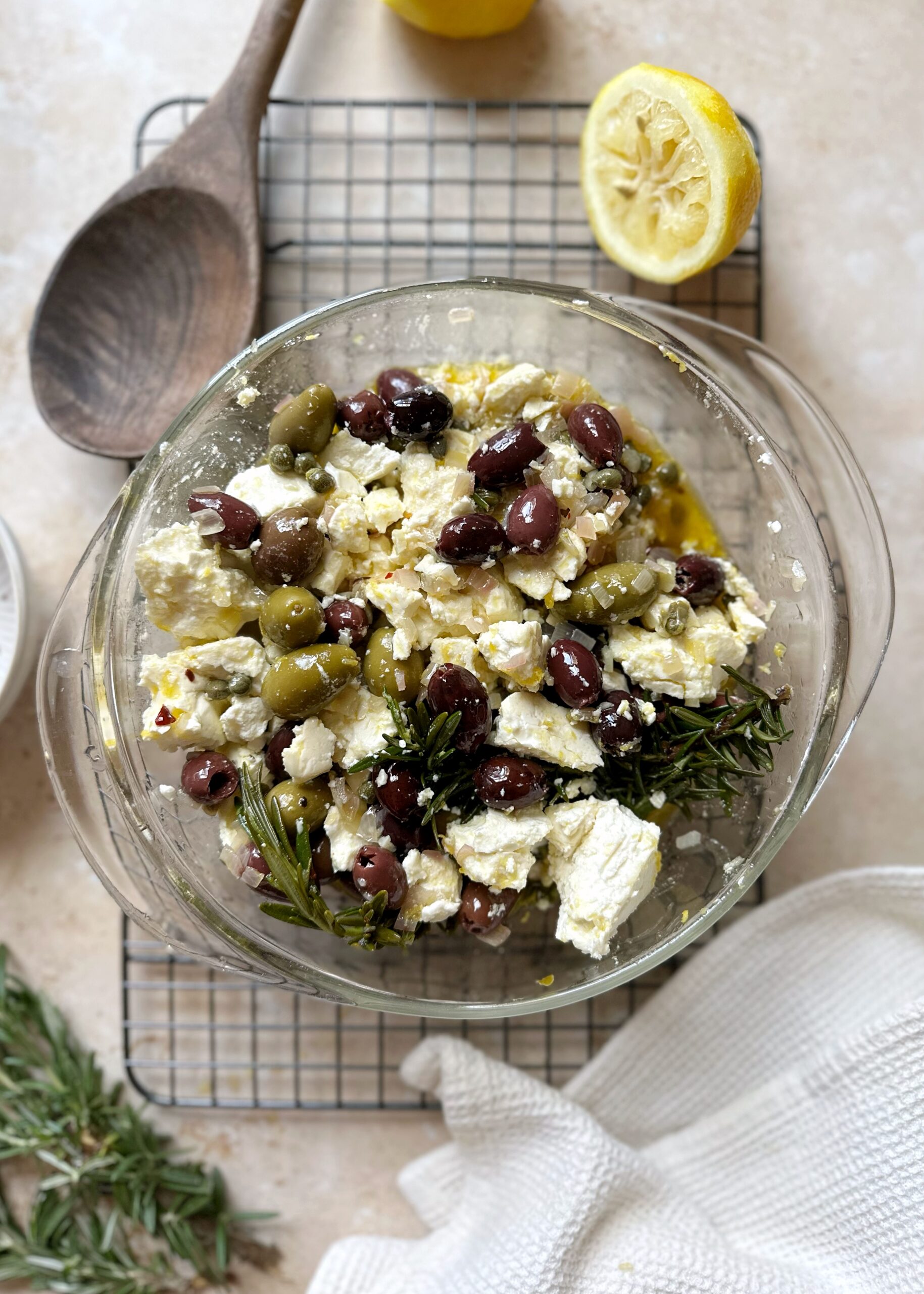 feta and olives marinating in a glass bowl