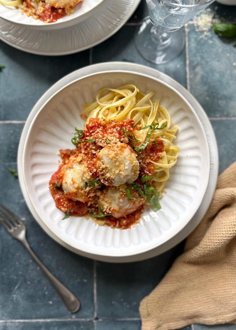 serving of baked chicken parmesan meatballs in bowl with pasta