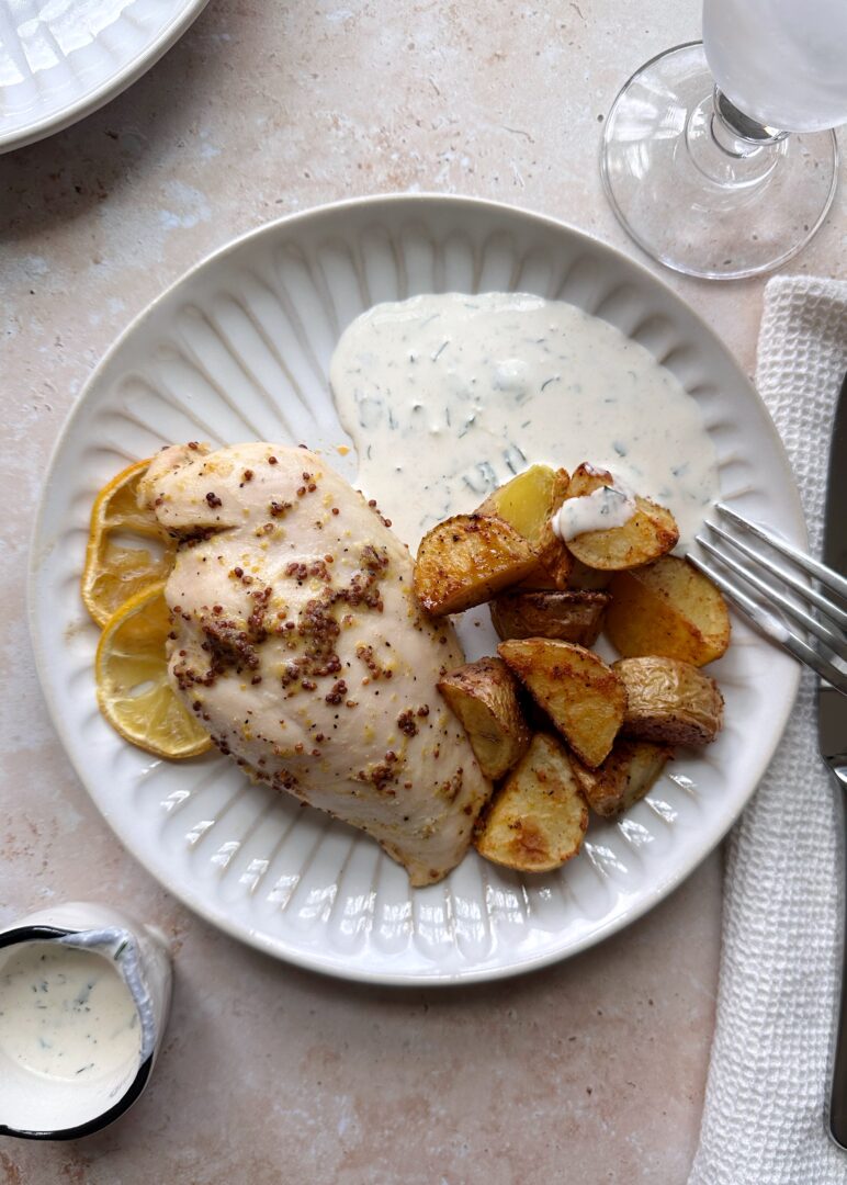 plate of lemon chicken and potatoes with a side of ranch