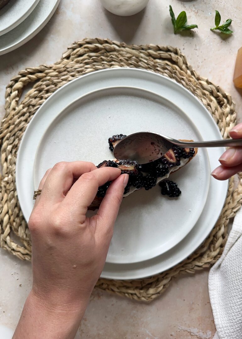 arranging blackberries on ricotta toast