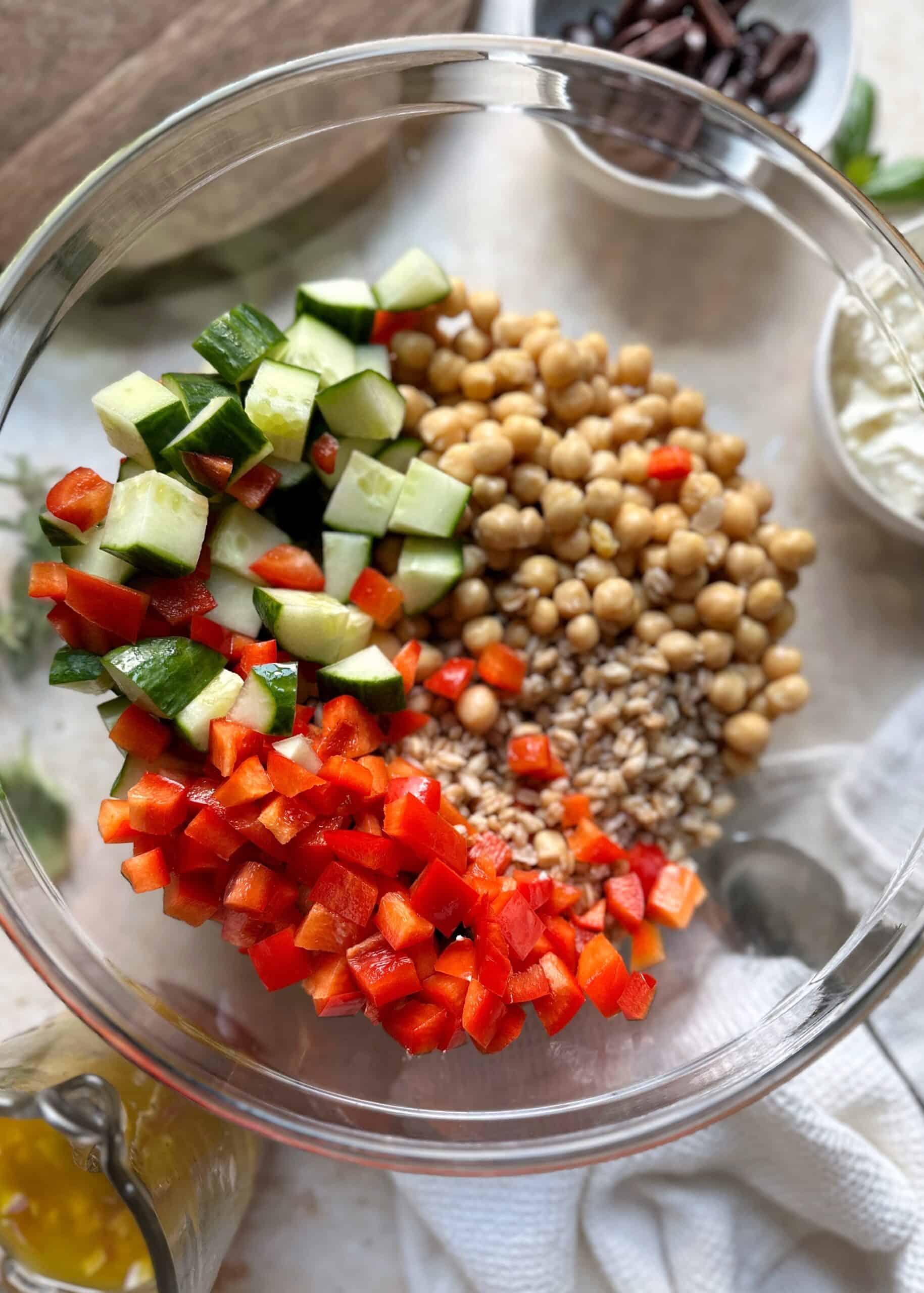 ingredients for a farro sald in a glass mixing bowl
