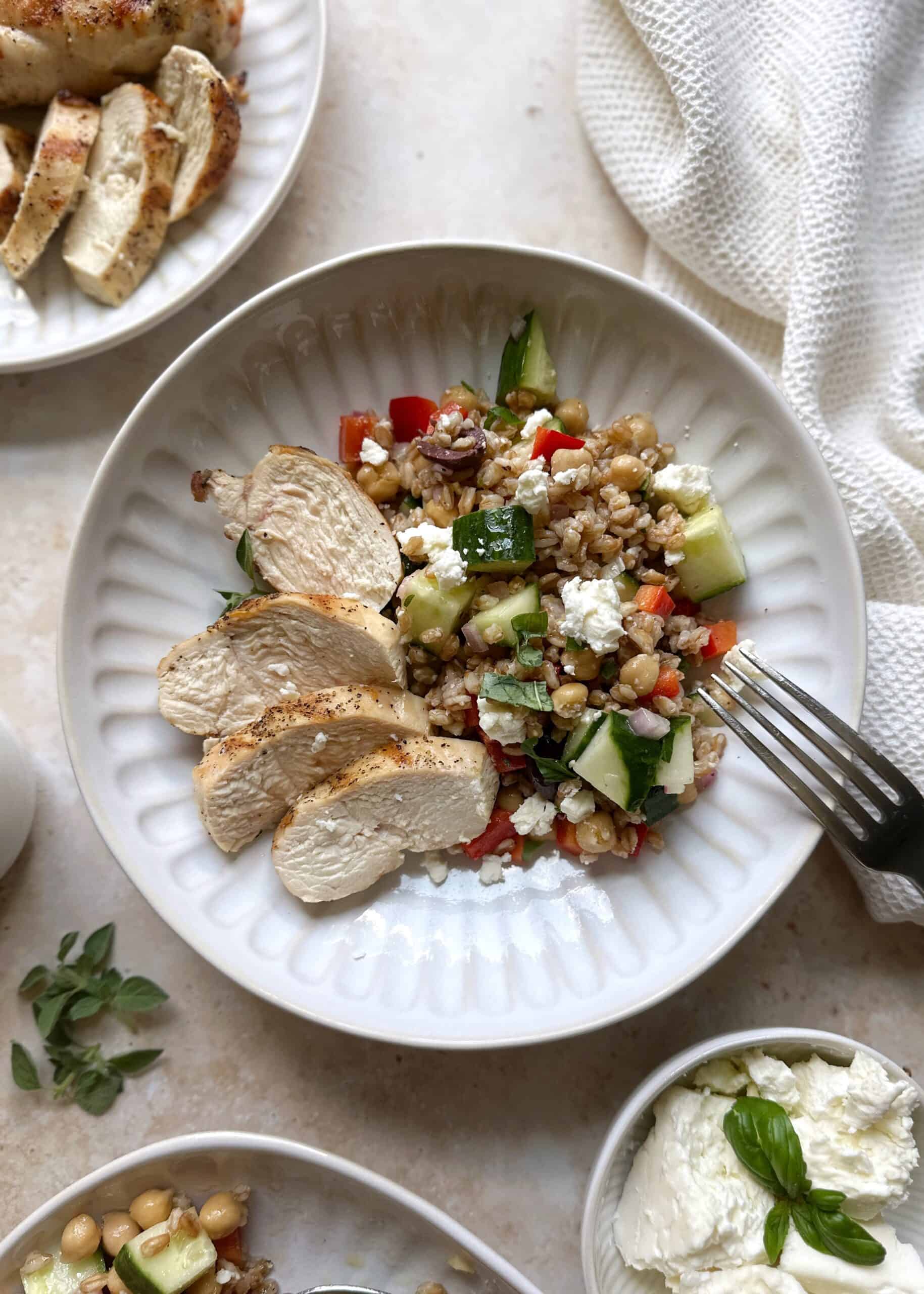 serving of greek farro salad with sliced grilled chicken