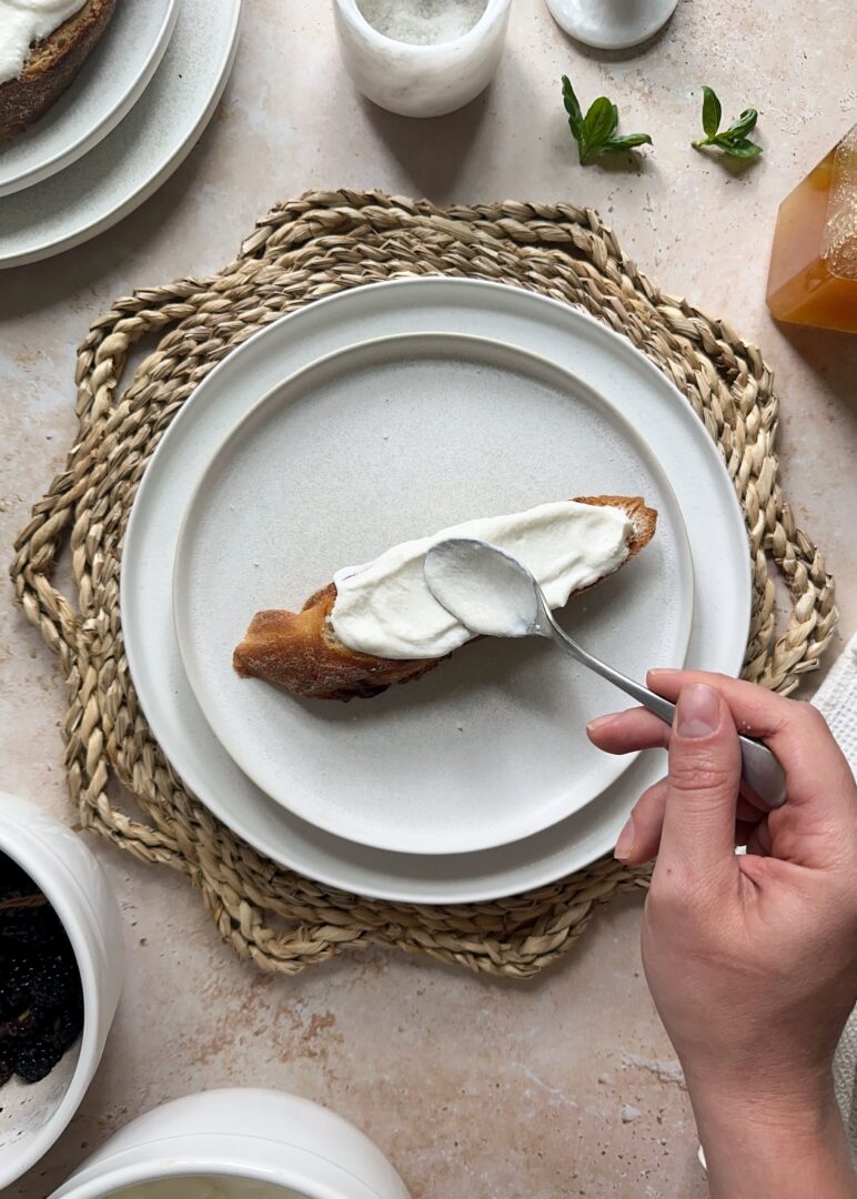 spreading whipped ricotta onto toast