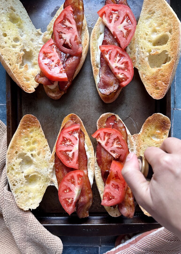 arranging tomatoes on caprese melt sandwiches