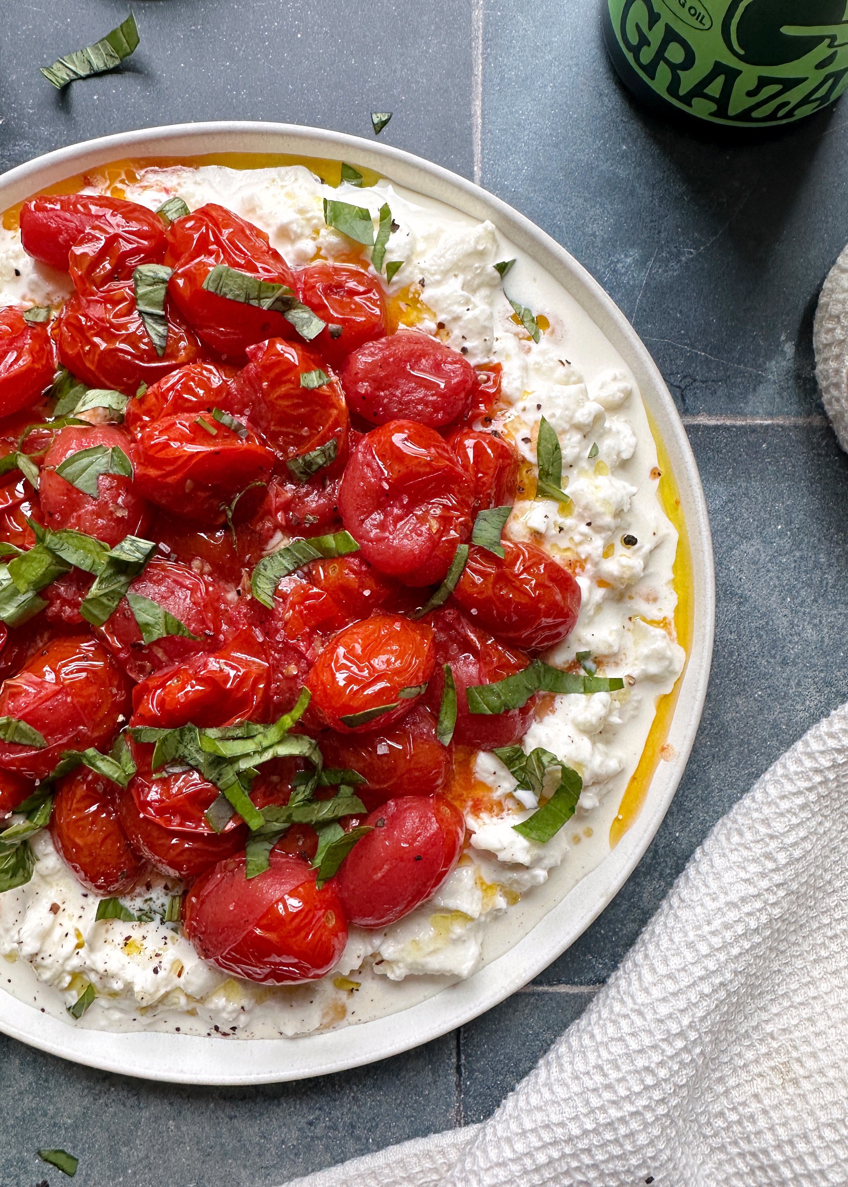 burst grape tomatoes on burrata with fresh basil