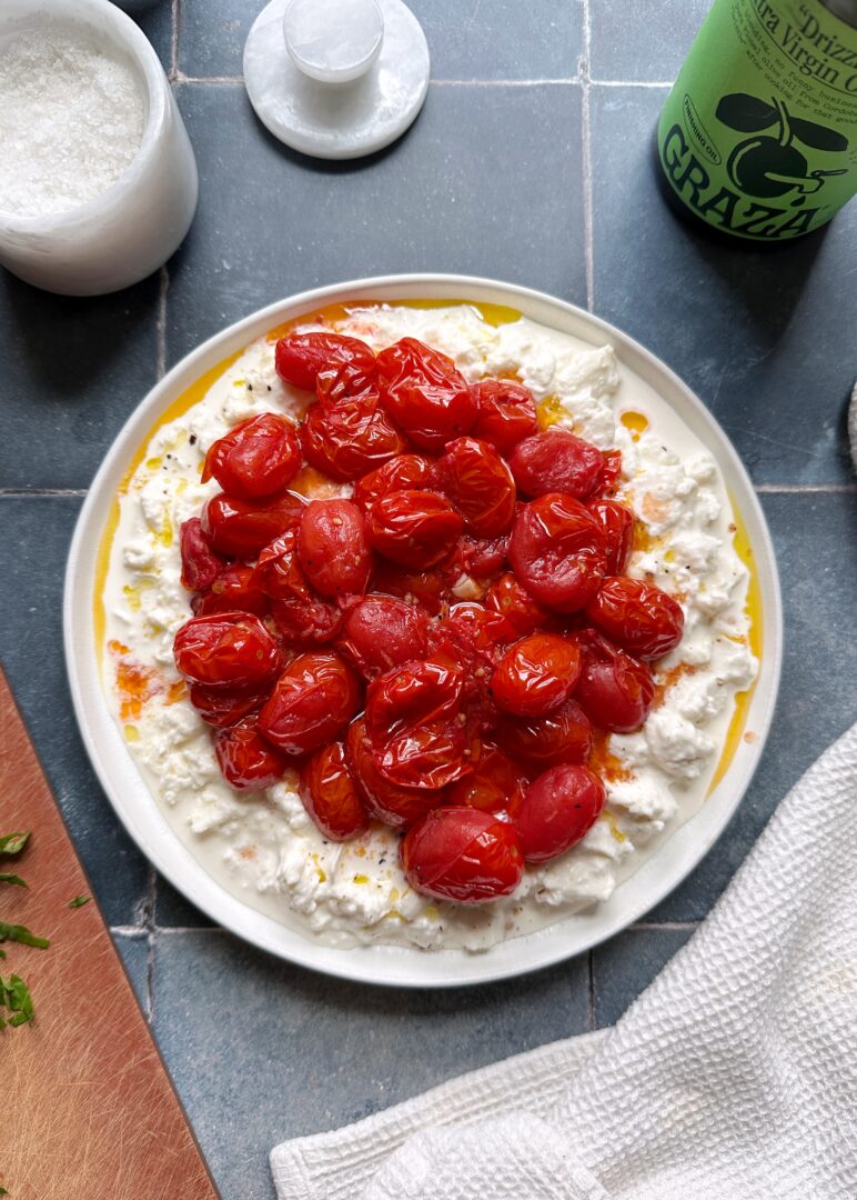 burst tomatoes over stracciatella cheese