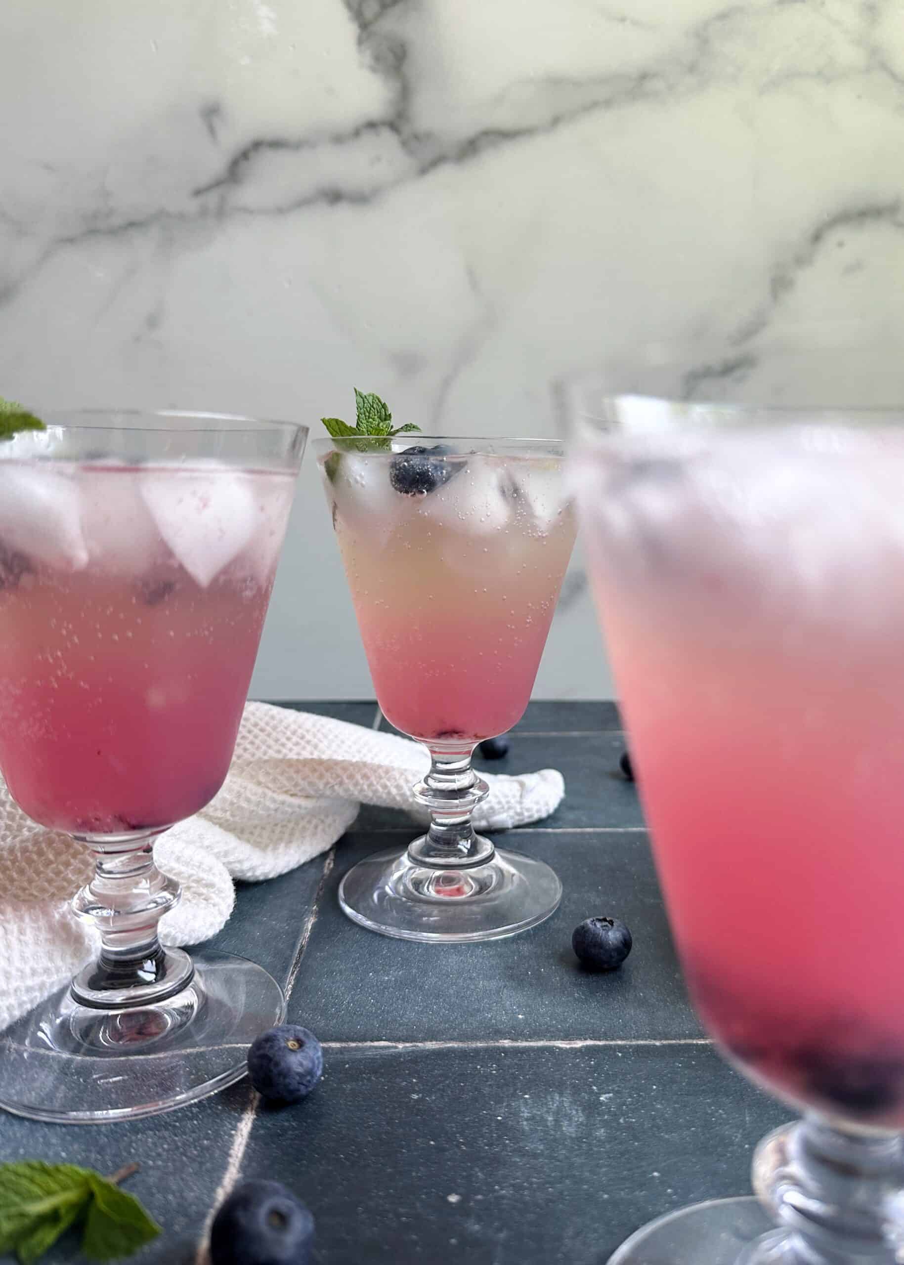 glasses of blueberry champagne mules