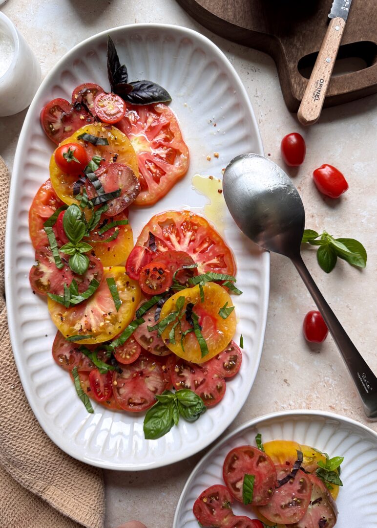 plate of mixed tomato salad with portion on the side